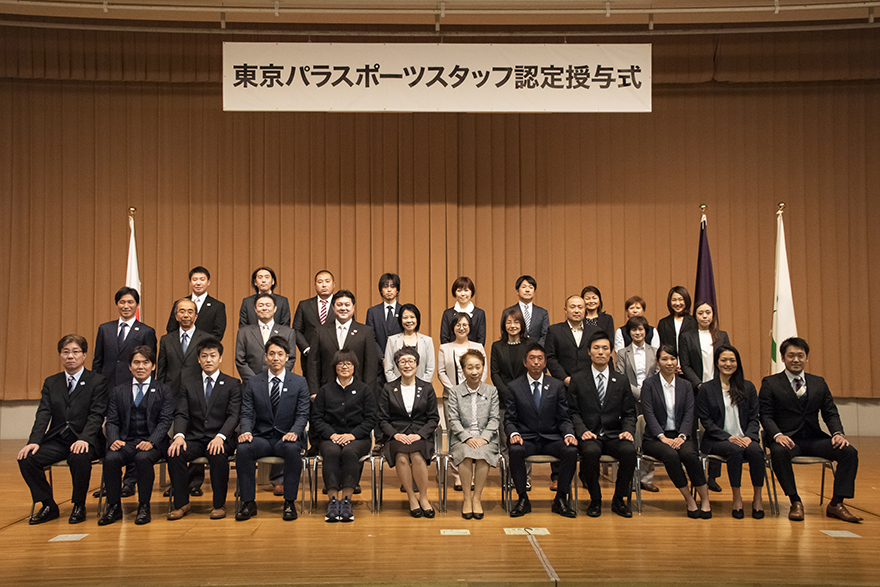 Newly accredited Tokyo Para Sports Staff sit together on stage for a group photograph