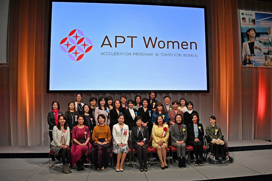 Group photo taken on stage with Governor Koike sitting in the center front row